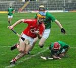 Description: Corks  Darren Sweetnam (Sam Maguires) evades the twin challenges of Limericks Brendan O Connor and David Reidy in the Munster Minor Hurling Championship Round 1 game at Pairc na nGael Limerick | Copyright: George Hatchell